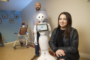 Diabetes patient and project participant Abigail with Dave the Robot and her dad Mark
